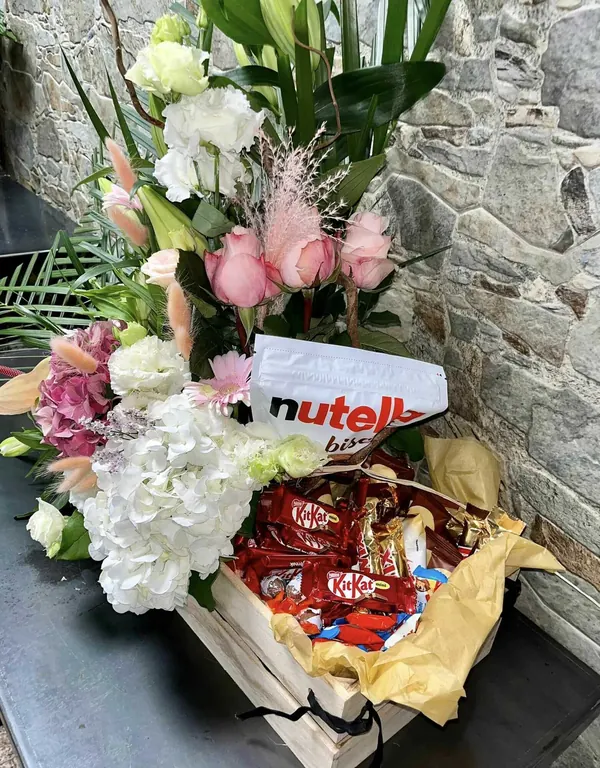 Bouquet de roses et d'hortensias avec des friandises et du chocolat