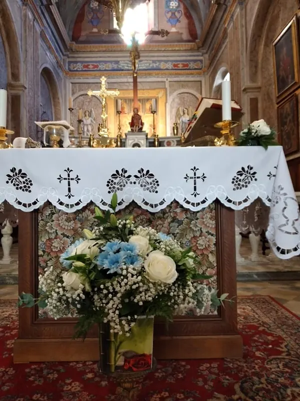 Composition de fleurs blanches et bleues devant l'autel d'une église