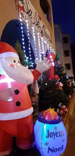 Père Noël lumineux et lanterne « Joyeux Noël » devant la boutique