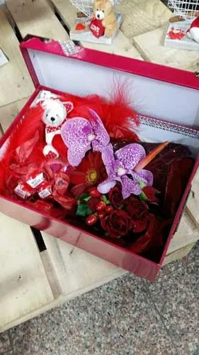 Coffret rouge garni de fleurs, d'orchidées et d'un ourson