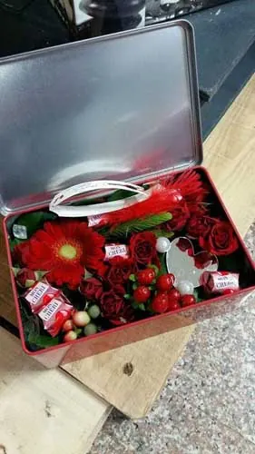 Coffret en métal garni de fleurs rouges et de friandises