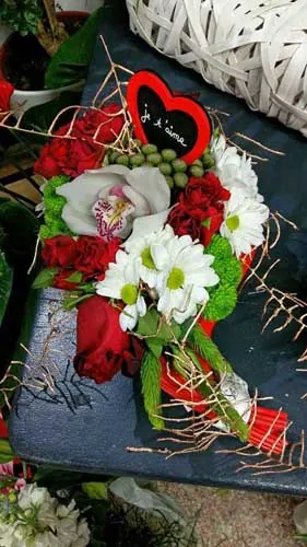 Composition de roses rouges, d'orchidée et de marguerites avec un cœur