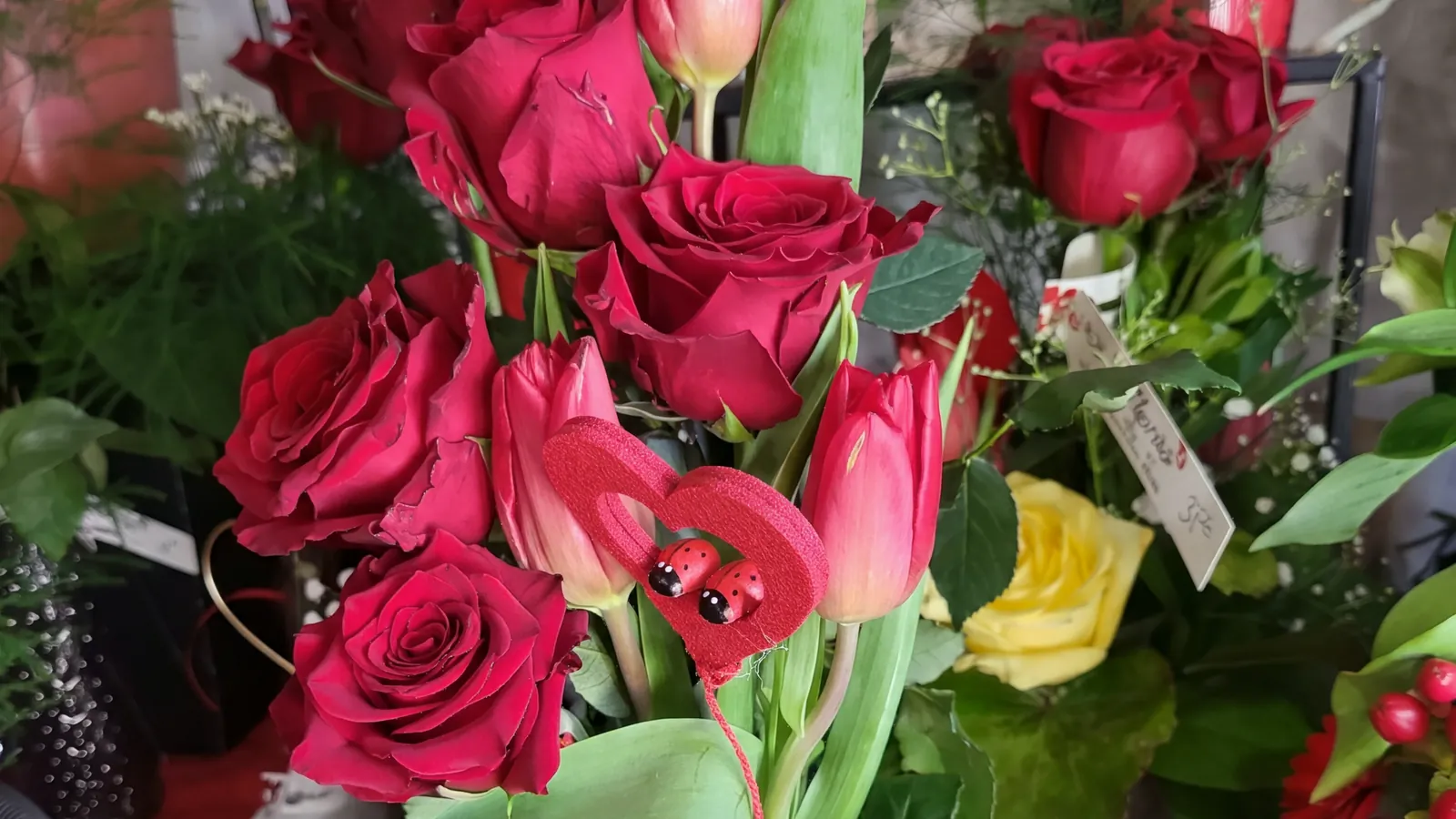 Bouquet de roses rouges et de tulipes, orné d'un cœur et de deux coccinelles